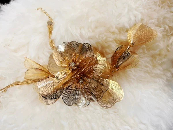 Elegant metal flower charm earrings and necklace set with delicate floral designs and metallic accents