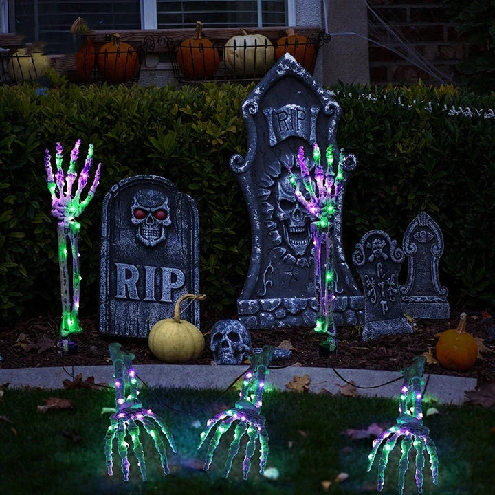 Solar-powered Halloween ground lamp with hand-shaped LED lights in purple and green colours, creating a spooky ambience in an outdoor courtyard