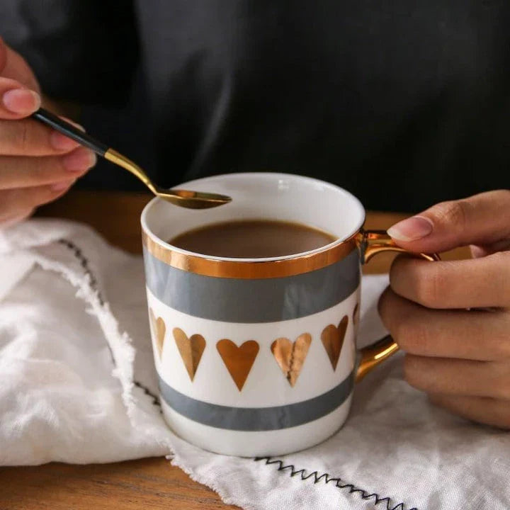 Elegant porcelain coffee mug with a lustrous gold heart design, perfect for enjoying hot beverages in style.