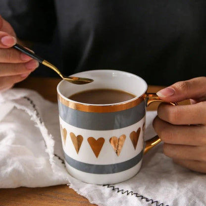Elegant porcelain coffee mug with a lustrous gold heart design, perfect for enjoying hot beverages in style.