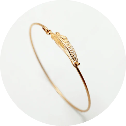 Elegant gold-coloured brass bracelet with a delicate falling leaf design, a nature-inspired accessory for everyday wear