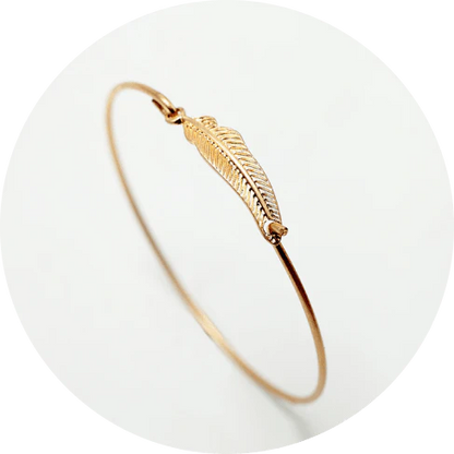 Elegant gold-coloured brass bracelet with a delicate falling leaf design, a nature-inspired accessory for everyday wear