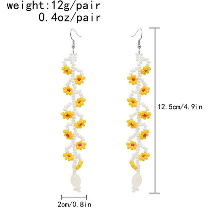 Elegant bohemian resin long tassel drop earrings in a vibrant yellow colour, featuring a mesmerising floral pattern and graceful movement