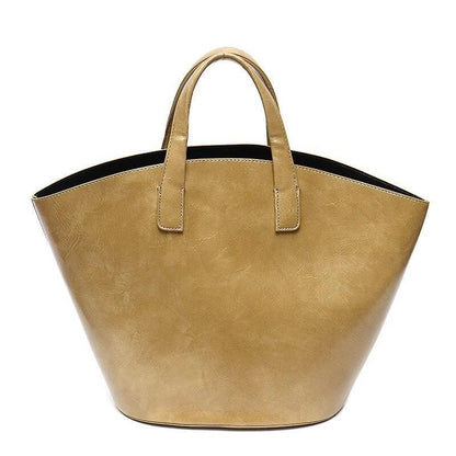 Elegant vegan leather tote bag with a unique bucket shape, short handles, and long straps for versatile carrying options