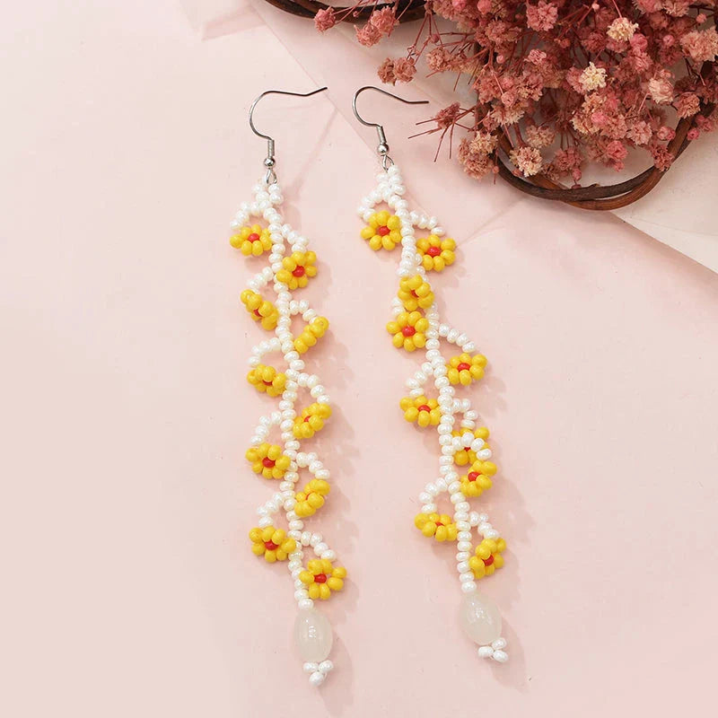 Elegant bohemian resin long tassel drop earrings in a vibrant yellow colour, featuring a mesmerising floral pattern and graceful movement