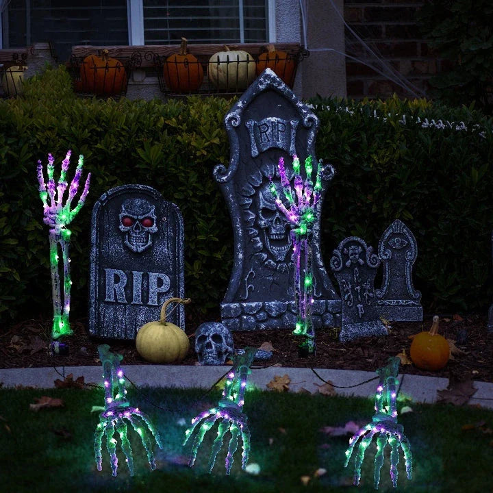 Solar-powered Halloween ground lamp with hand-shaped LED lights in purple and green colours, creating a spooky ambience in an outdoor courtyard