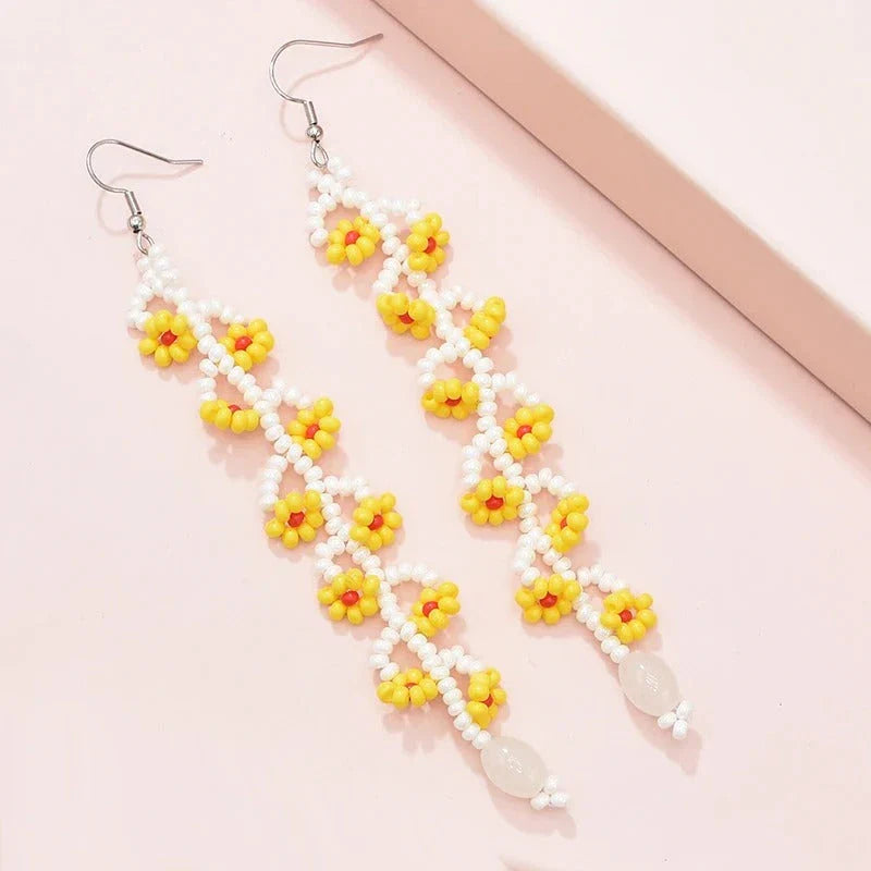 Elegant bohemian resin long tassel drop earrings in a vibrant yellow colour, featuring a mesmerising floral pattern and graceful movement