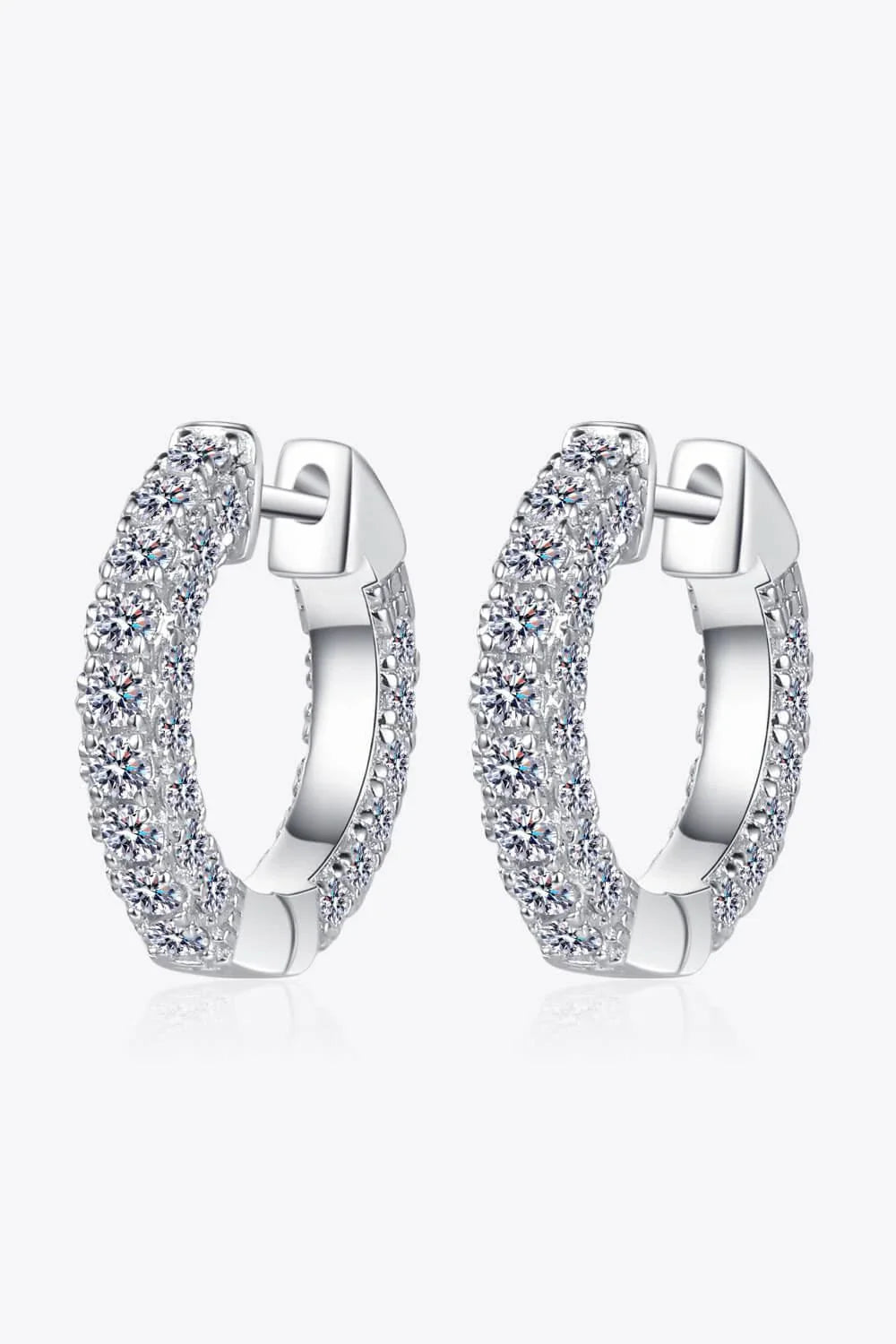 Pair of elegant sterling silver huggie earrings adorned with dazzling moissanite stones, showcasing a minimalist and sophisticated design.