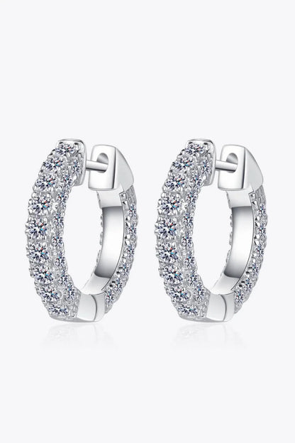 Pair of elegant sterling silver huggie earrings adorned with dazzling moissanite stones, showcasing a minimalist and sophisticated design.