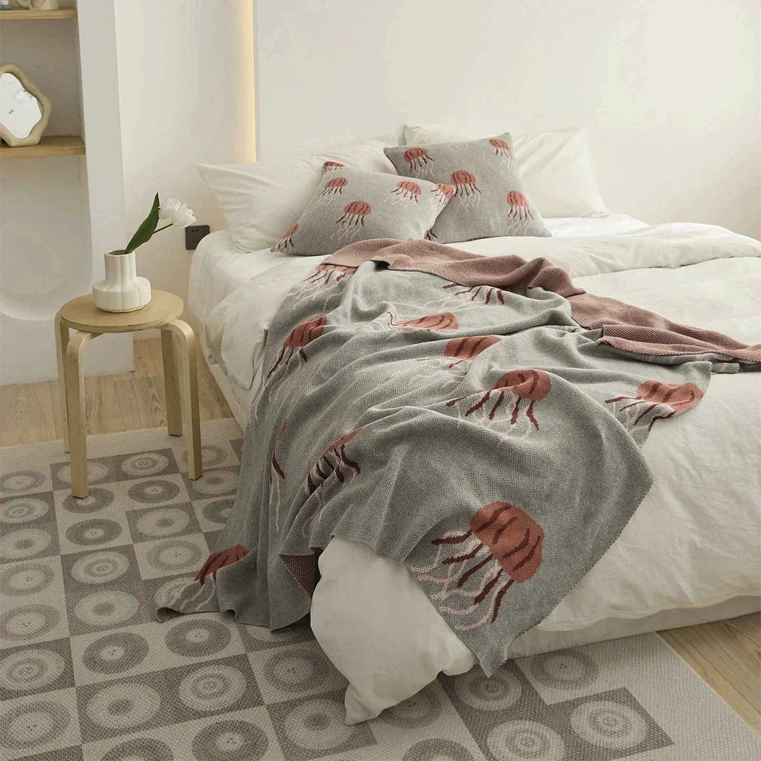 Cosy jellyfish-patterned cotton knit throw blanket in green and grey colours, showcasing its soft, plush texture and unique design.
