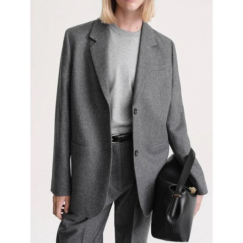 Elegant and refined women's woollen blazer with a wide-waisted silhouette, single-breasted closure, and turn-down collar