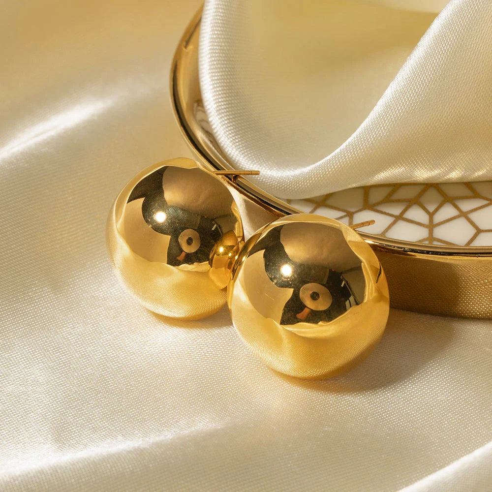 A pair of stylish, 18K gold-plated hemispherical cutout earrings with a sleek, sophisticated design