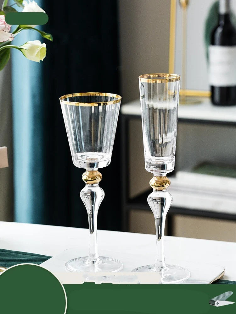 Elegant crystal wine glasses with refined gold vertical patterns, perfect for enjoying fine wines and champagne