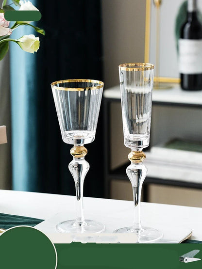 Elegant crystal wine glasses with refined gold vertical patterns, perfect for enjoying fine wines and champagne