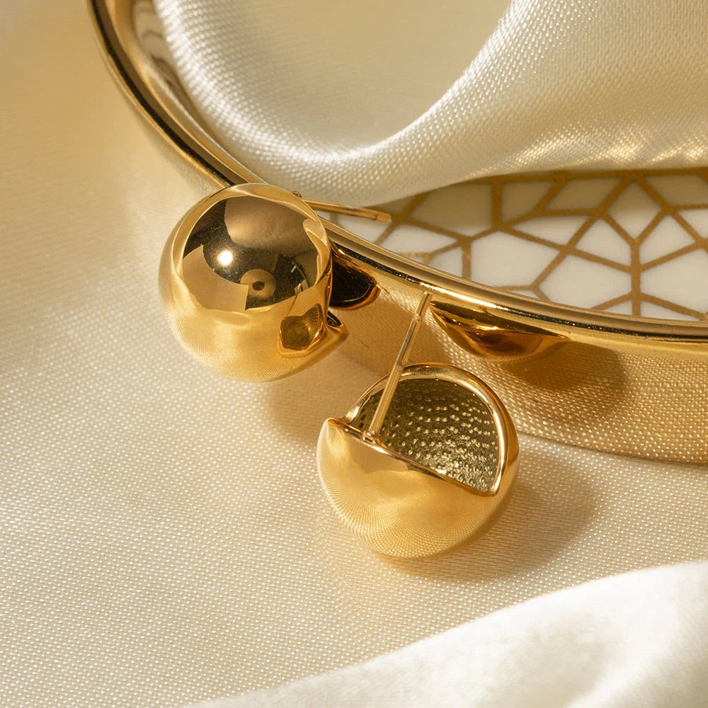 A pair of stylish, 18K gold-plated hemispherical cutout earrings with a sleek, sophisticated design