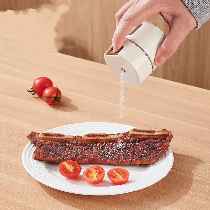 A modern, wall-mounted glass salt dispenser with magnetic suction and precise quantitative control for effortless kitchen organisation.