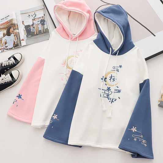 A cosy, velvet-padded hooded sweater with playful alphabet sleeves in pink and blue colours