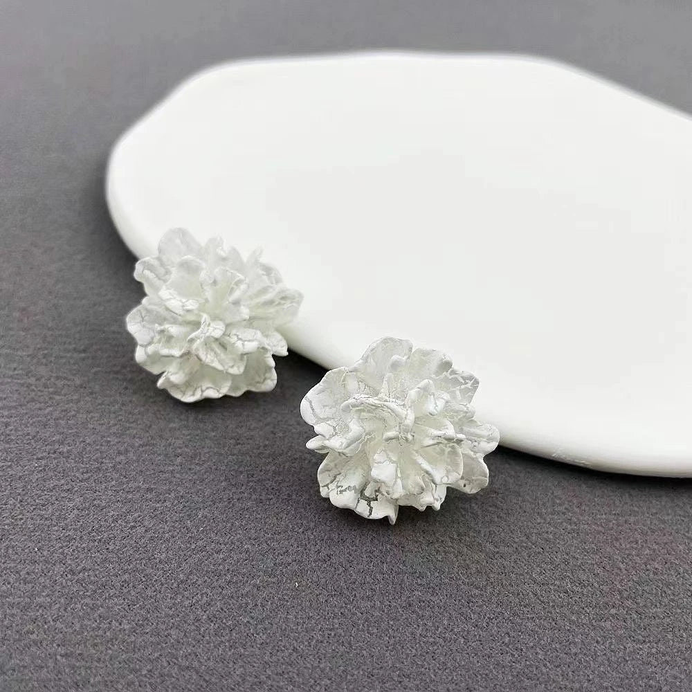 Elegant white floral stud earrings with a unique and captivating design, perfect for fashion-forward women in the UK