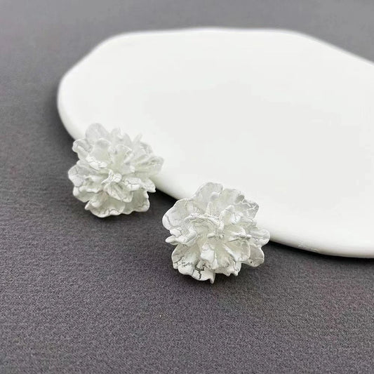 Elegant white floral stud earrings with a unique and captivating design, perfect for fashion-forward women in the UK