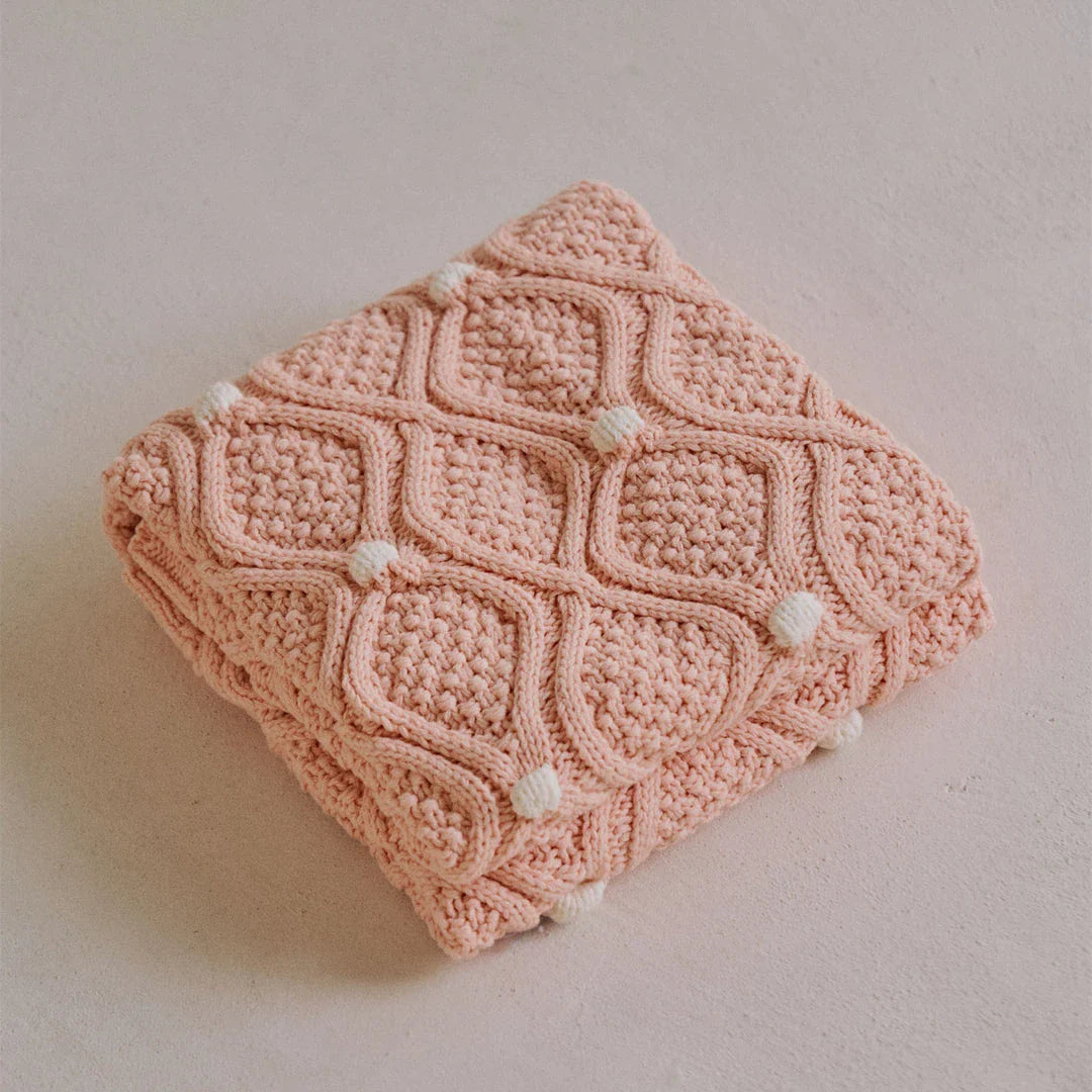 Cosy chunky knit blanket with charming pompoms in multiple sizes and colours for elegant home décor