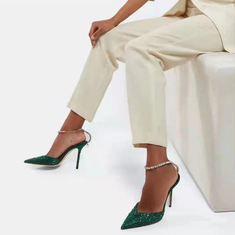 Elegant stiletto sandals with rhinestone chain embellishment, showcasing a sleek pointed toe design and matte finish for a sophisticated British-inspired look.