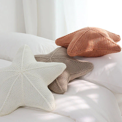 Artfully hand-knitted starfish-shaped cushion in a range of sophisticated colour options, providing plush comfort and coastal charm for any living space.