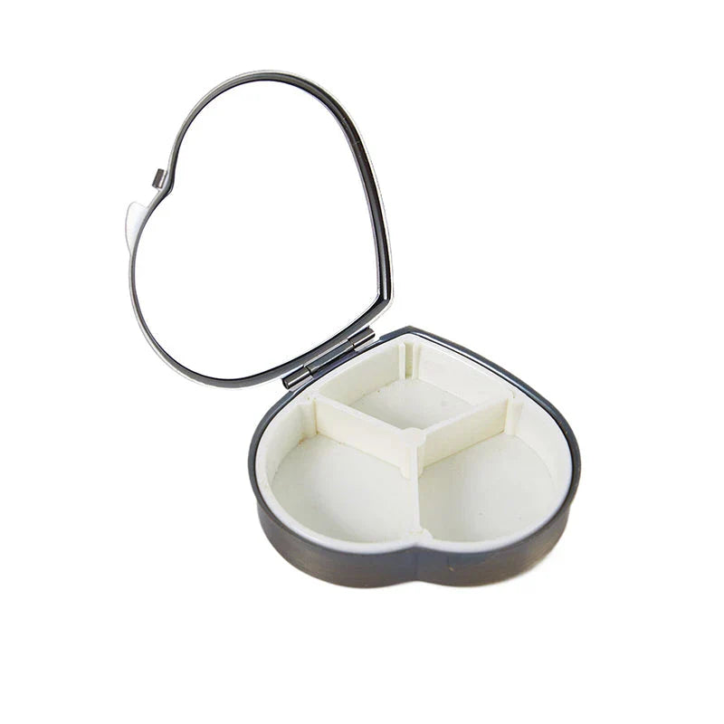 Heart-shaped metal pill box with built-in mirror for convenient storage and touch-ups on the go