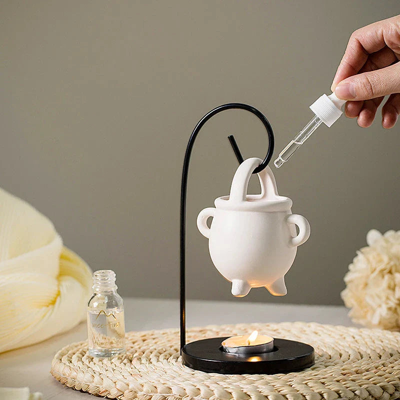 Captivating iron frame essential oil diffuser and candle holder with a unique witch's soup cup design