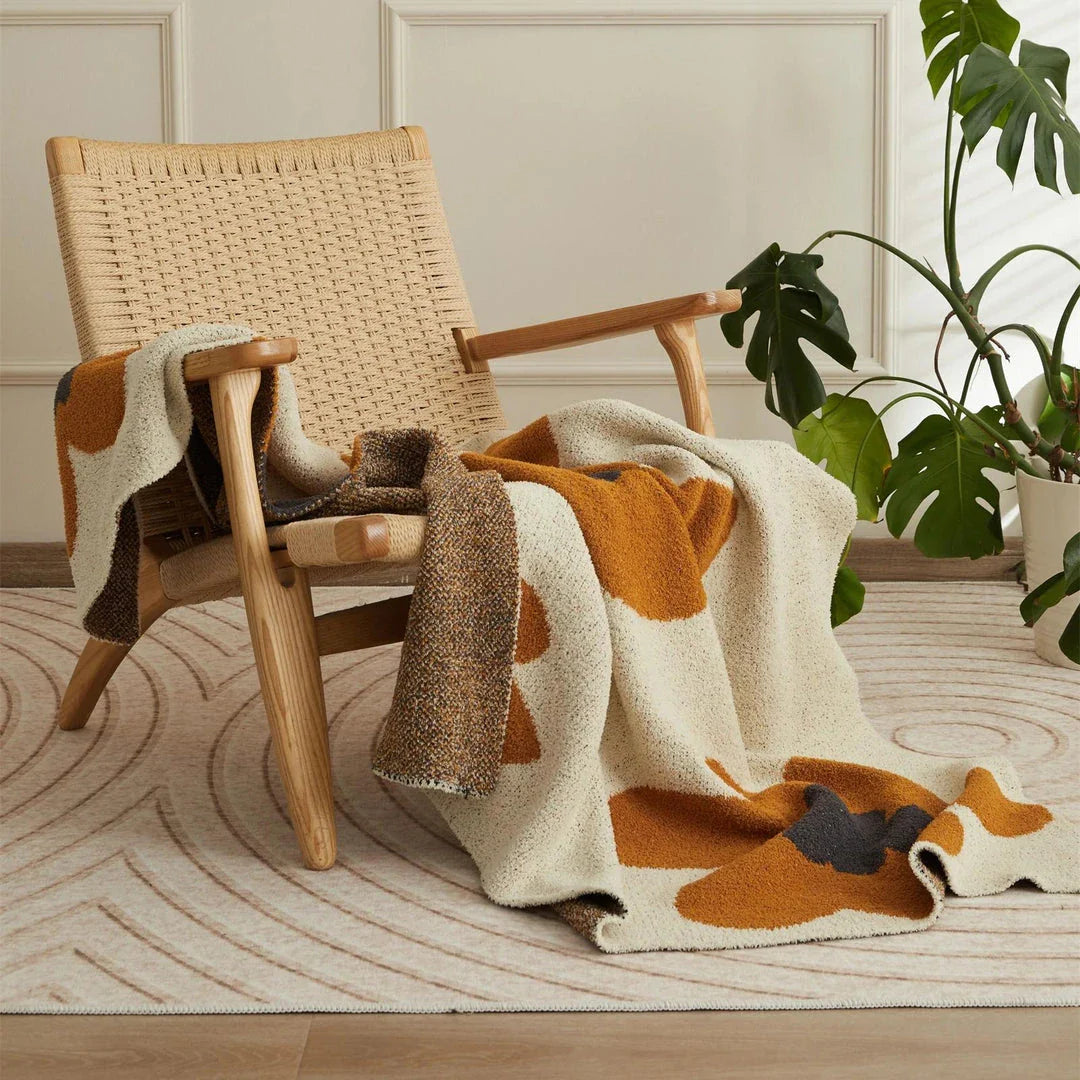 Cosy floral knitted throw blanket in red, grey, and orange shades - a high-quality microfibre accessory for year-round comfort and style