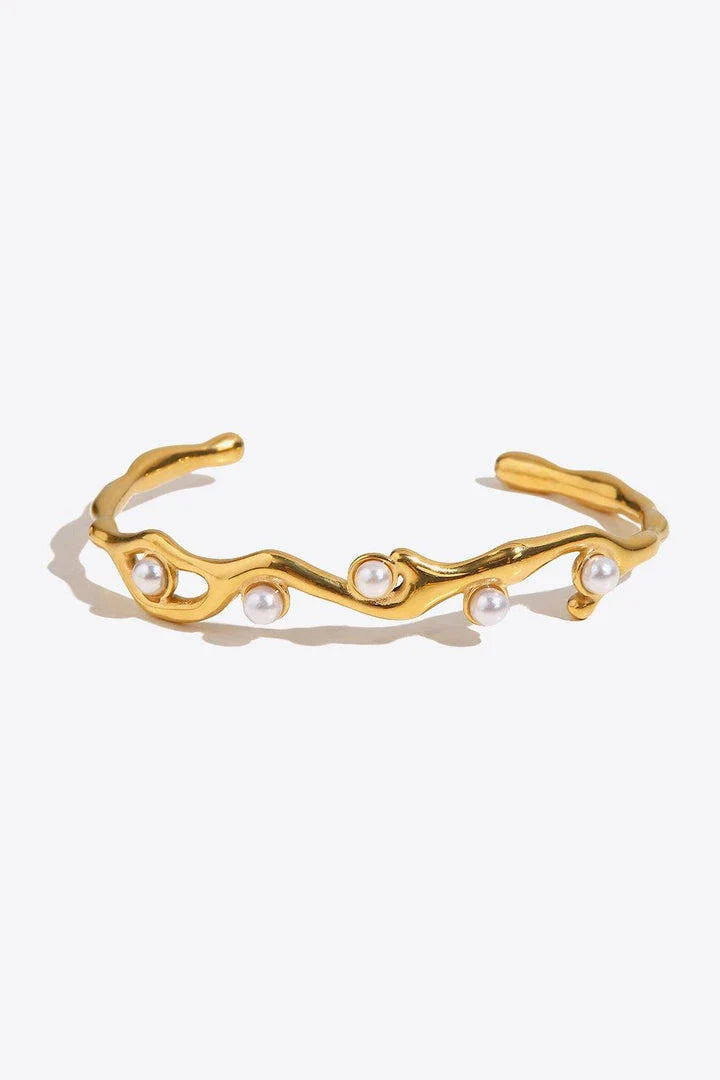Elegant 18k gold-plated bracelet with shimmering synthetic pearls, showcasing a sleek, open design for a comfortable and stylish fit.