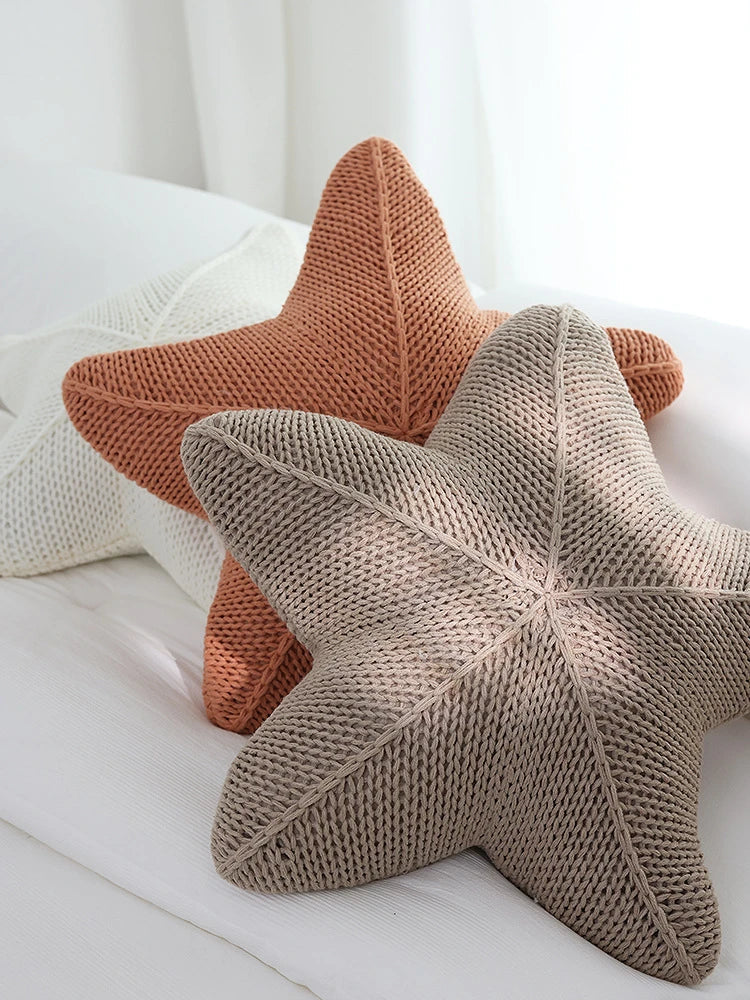 Artfully hand-knitted starfish-shaped cushion in a range of sophisticated colour options, providing plush comfort and coastal charm for any living space.