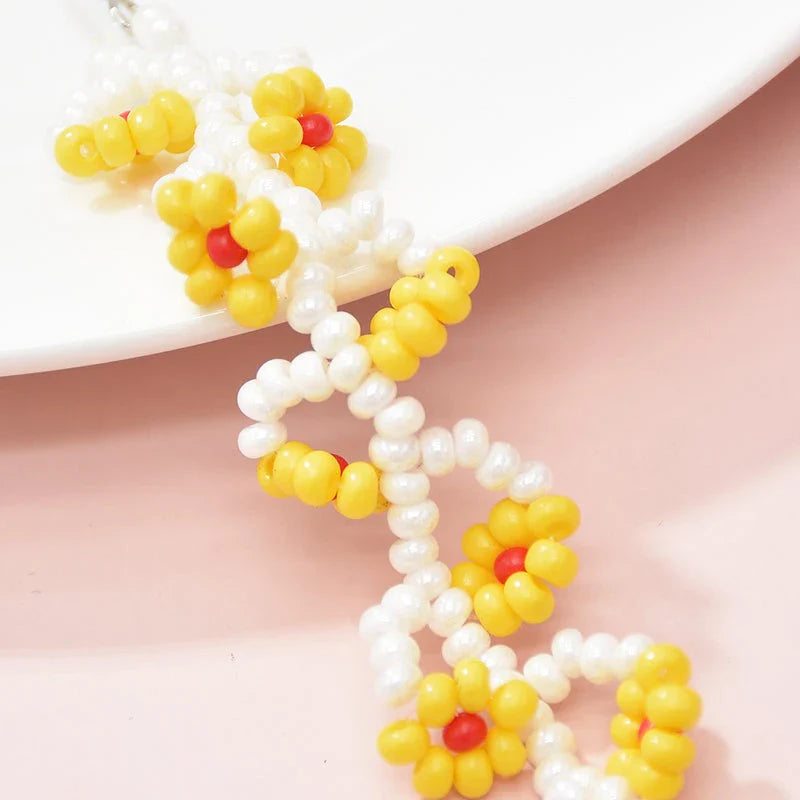 Elegant bohemian resin long tassel drop earrings in a vibrant yellow colour, featuring a mesmerising floral pattern and graceful movement