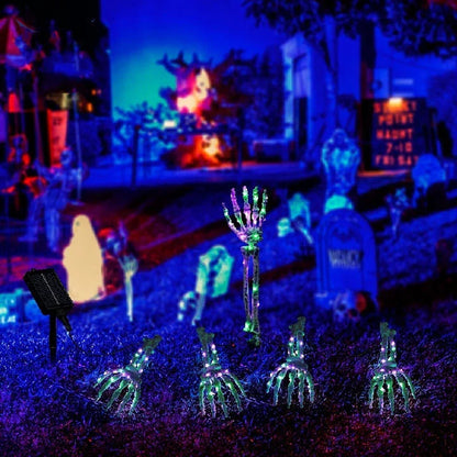 Solar-powered Halloween ground lamp with hand-shaped LED lights in purple and green colours, creating a spooky ambience in an outdoor courtyard