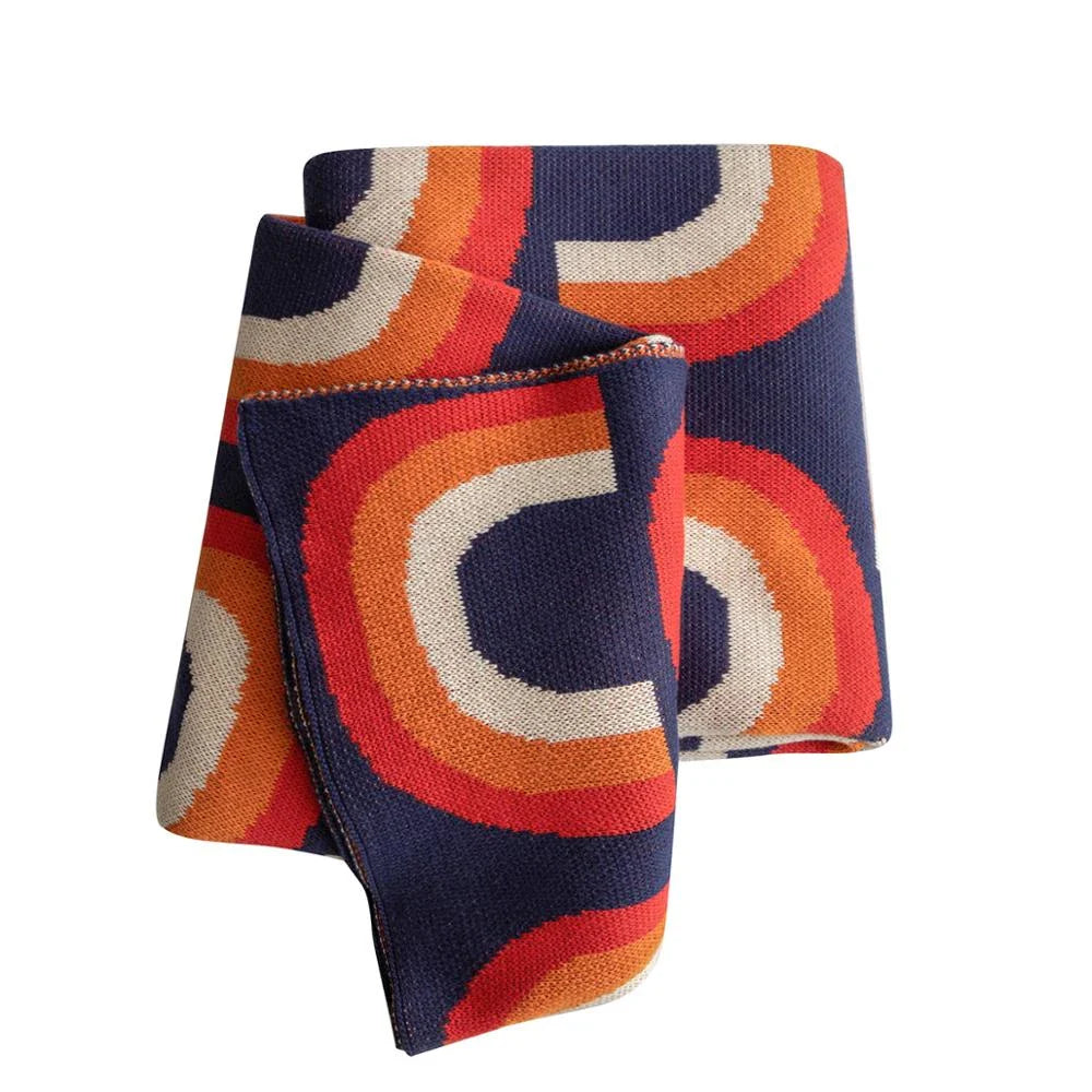 Cosy rainbow-patterned cotton knit throw blanket in various plaid and stripe designs, showcasing vibrant colours and a soft, comfortable texture.