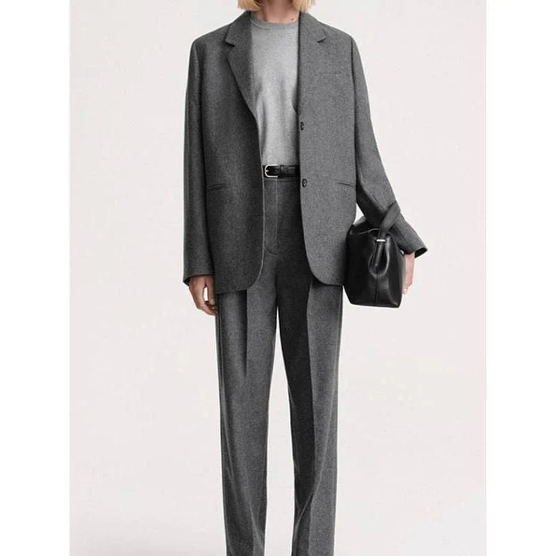 Elegant and refined women's woollen blazer with a wide-waisted silhouette, single-breasted closure, and turn-down collar