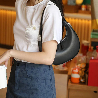 Elegant leather shoulder bag with a unique half-moon shape, designed for the modern British woman