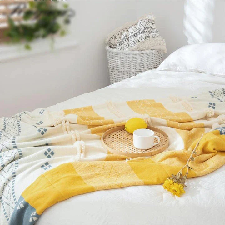 Cosy cotton tufted throw blanket with a geometric pattern and tassels in a soft yellow colour