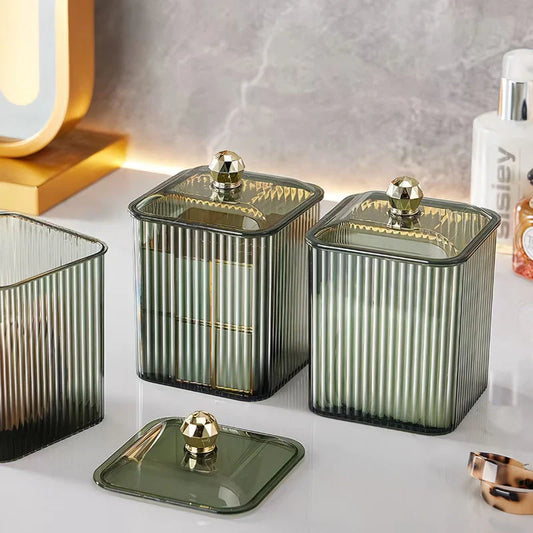 A clear acrylic q-tip holder and dispenser with a removable lid, providing stylish and functional storage for bathroom essentials.
