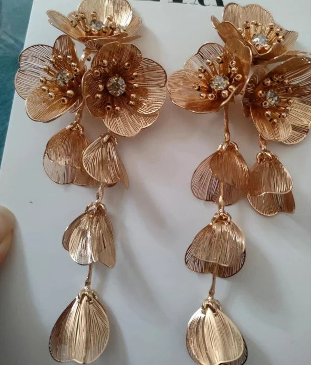 Elegant metal flower charm earrings and necklace set with delicate floral designs and metallic accents