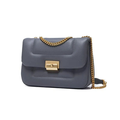 Grey leather crossbody bag with adjustable metal shoulder strap and secure hasp closure