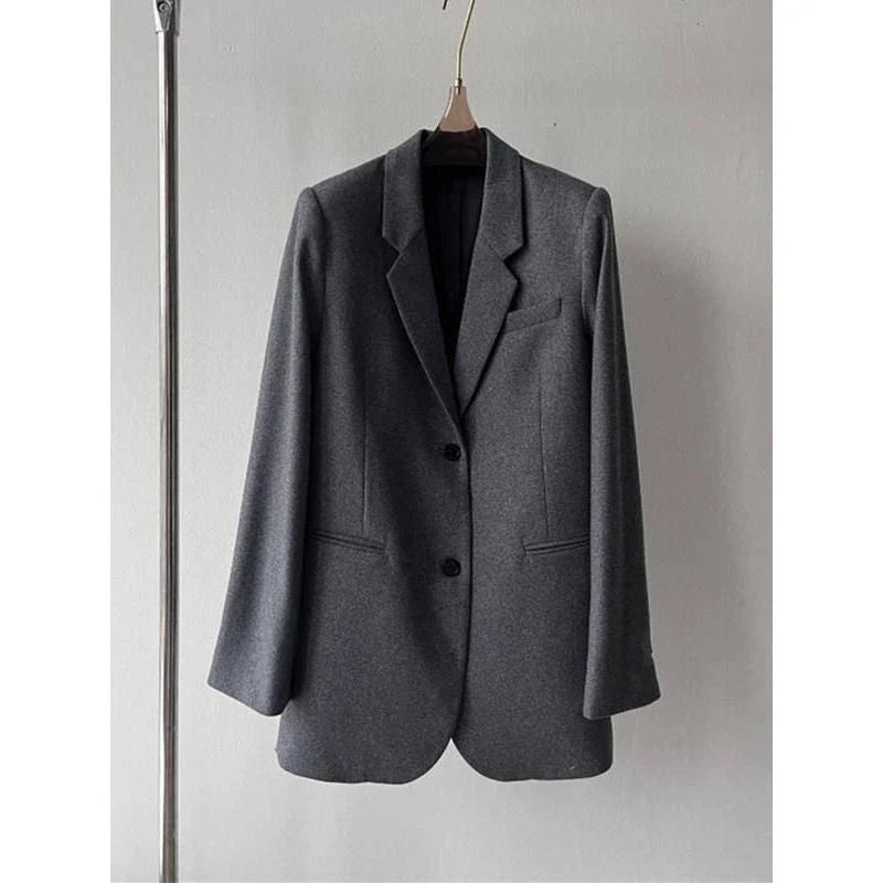 Elegant and refined women's woollen blazer with a wide-waisted silhouette, single-breasted closure, and turn-down collar