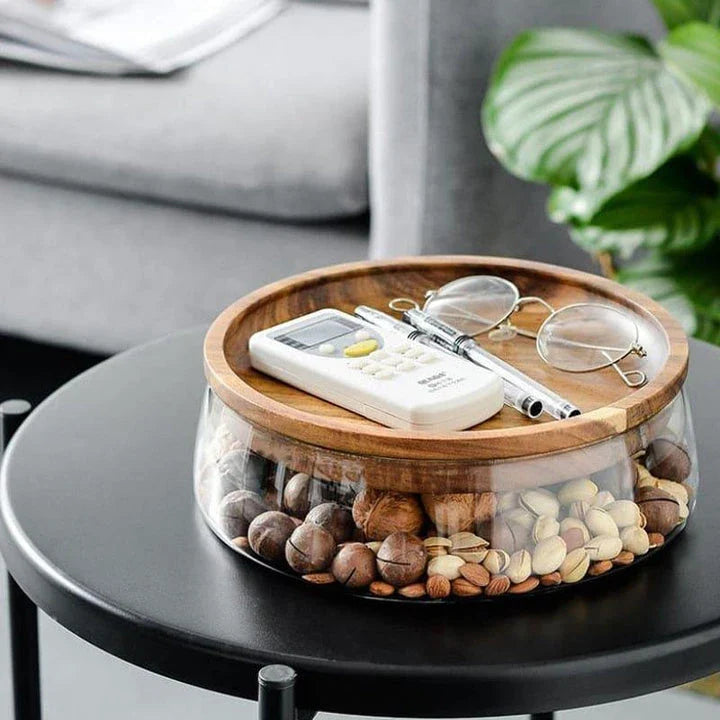 A transparent glass storage canister with a wooden lid, offering elegant and functional kitchen storage