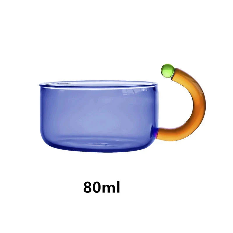 Elegant glass teapot and teacup set in vibrant contrasting colours, designed for a refined tea experience