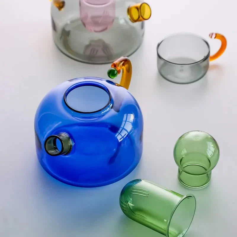 Elegant glass teapot and teacup set in vibrant contrasting colours, designed for a refined tea experience
