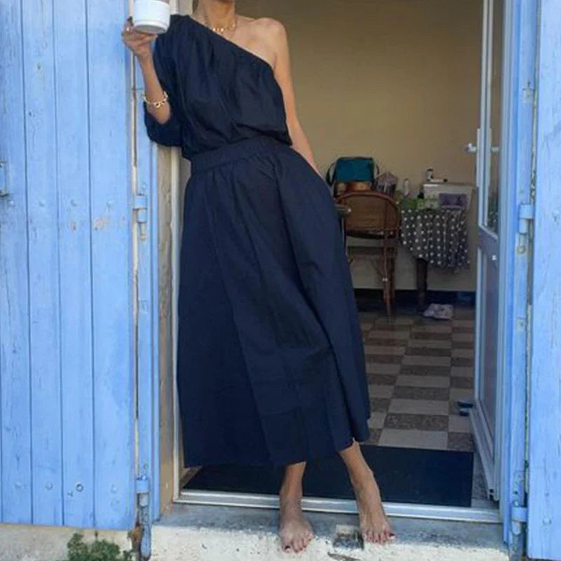 Elegant two-piece set with oblique shoulder blouse and midi skirt in black colour