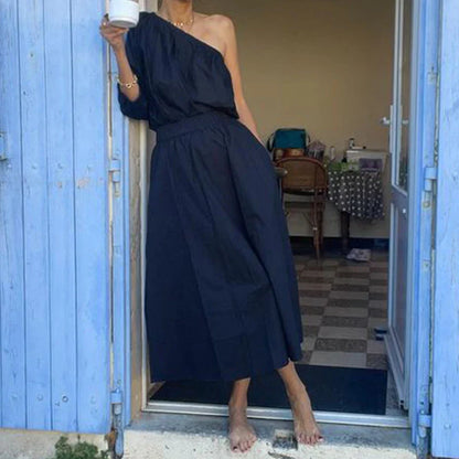 Elegant two-piece set with oblique shoulder blouse and midi skirt in black colour