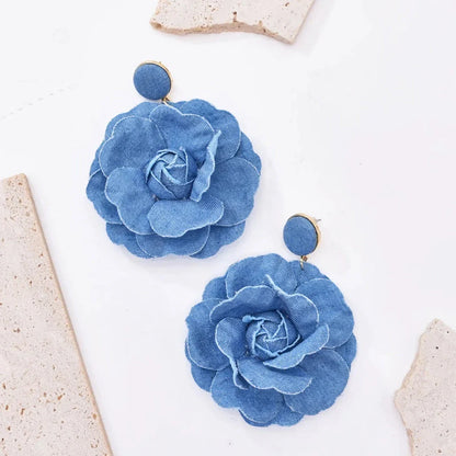 Elegant denim drop earrings with intricate details, a versatile accessory that adds a touch of refined British style to any outfit.