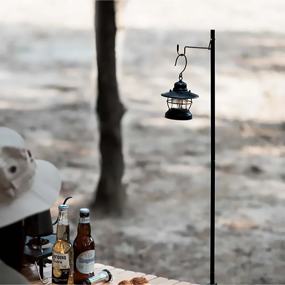 Adjustable camping lantern stand with detachable hangers, made of corrosion-resistant stainless steel and aluminium alloy for stable and elevated lighting.
