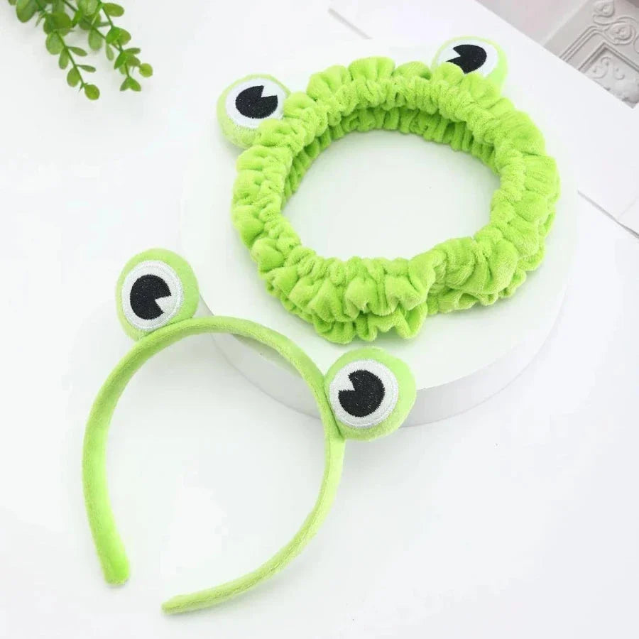 Charming frog-themed headband with plush coral fleece material and elastic band for a comfortable, customized fit