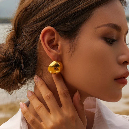A pair of stylish, 18K gold-plated hemispherical cutout earrings with a sleek, sophisticated design